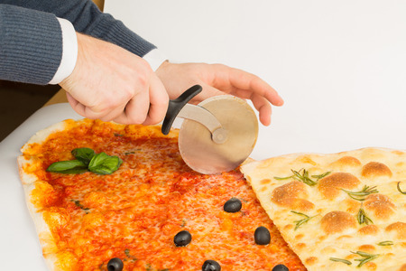 Photo of a man who cuts the pizza special knifeの写真素材