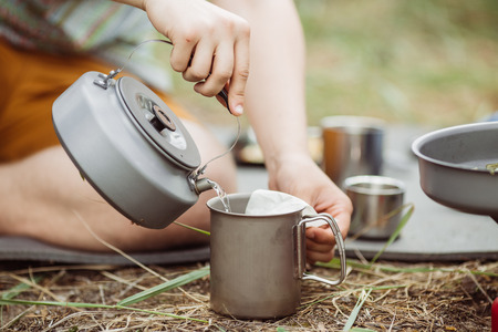 A person pouring hot water from a kettle for his teaの写真素材