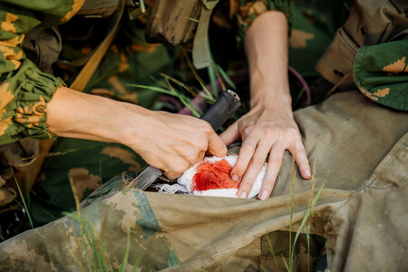 female military doctor to help the wounded soldierの写真素材