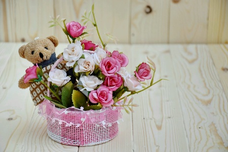 Romantic artificial rose in basket with bear.の素材