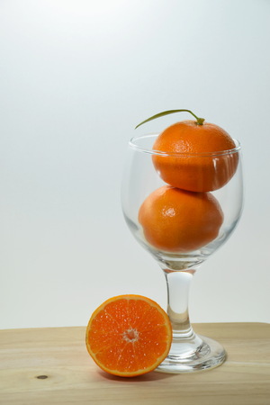 Orange in glass on wood tableの写真素材