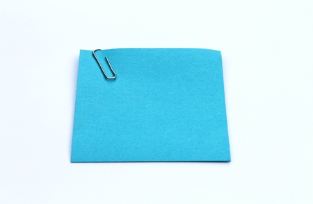 Blank sticky note with paper clip on white background