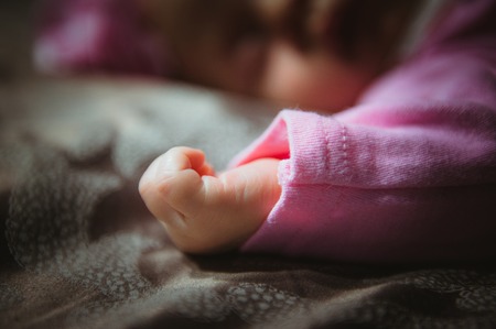 Image of cute little girl in pink suit indoor. Newborn baby, caucasian child.の写真素材