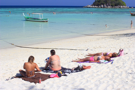 SATUN, THAILAND - MARCH 14, 2014 Foreigners sunbathing on beach at Lipe islandのeditorial素材