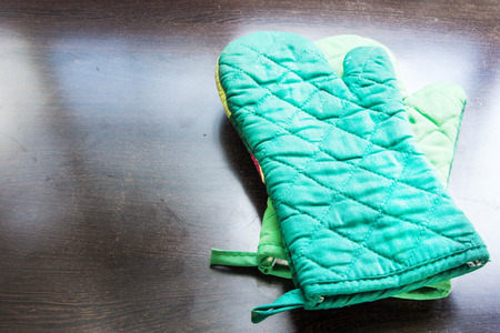 Green Kitchen protective glove on wooden backgroundの写真素材