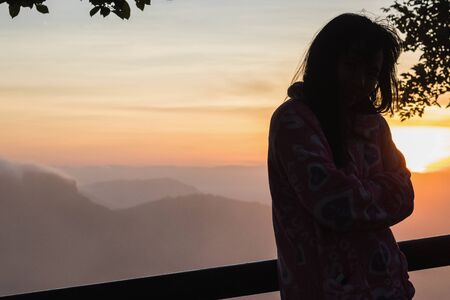 Silhouettes of woman on the mountian at sunrise.の写真素材
