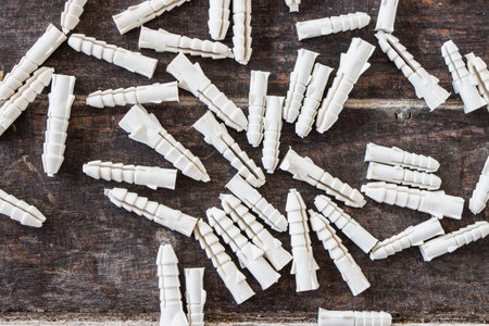Plastic wall plugs on wooden background.の写真素材