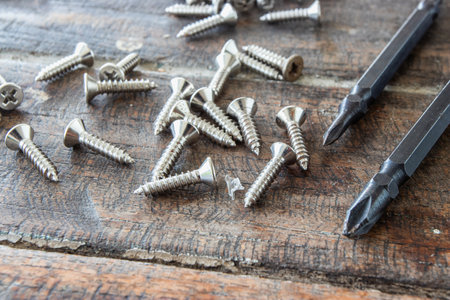 Head of screwdrivers and screws on wooden background.の写真素材