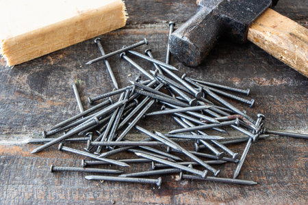 Hammer and nails on wooden background. The instruments for repairman, carpenter, builder.の写真素材