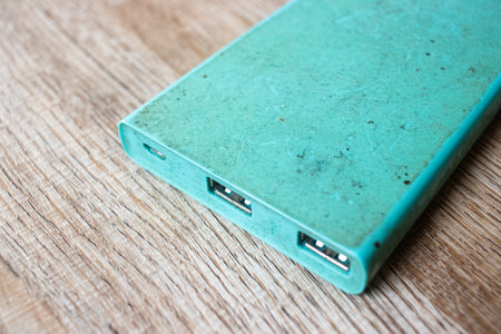 Old and dirty power bank on the wooden table.の写真素材