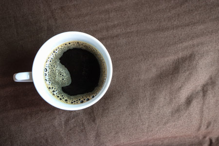 Black coffee is served on a brown bed to wake up in the morning.の写真素材
