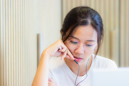 Work from home during the outbreak of the virus. Attractive young woman working with laptop and meeting video conferrence with the team.の写真素材
