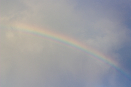 Rainbow in the cloudy sky after the rainの写真素材