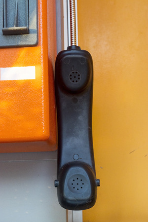 orange telephone receiver with shawdow light.