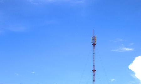 Mobile phone transmitter pole on blue sky and clouds.の写真素材