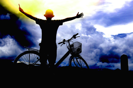 Silhouette of a man on bike,dark background.play mobile phoneの写真素材