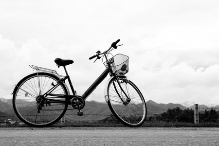 A bicycle stands at near of a runway and mountainの写真素材