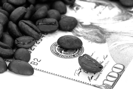 coffee Beans isolated on banknotes background area for copy space and selective focus. Coffee is an economic crops.の写真素材