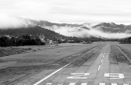 Airport runway with mountain in countryside with fog on mountain.の写真素材