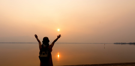 strong confidence woman open arms under the sunrise at seaside.