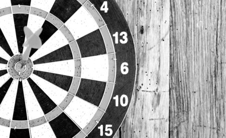 Bullseye is a target of business. Dart is an opportunity and Dartboard on old wood background.の写真素材