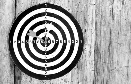 Bullseye is a target of business. Dart is an opportunity and Dartboard on old wood background.の写真素材
