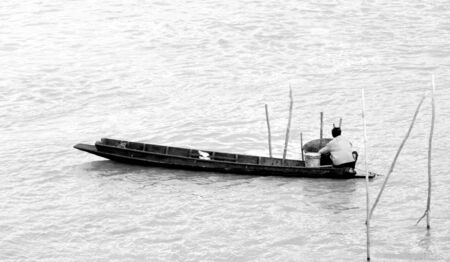 Old fisherman on the boat in lake.の写真素材