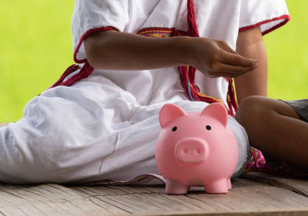 High ground child saving money in piggy bank.の写真素材