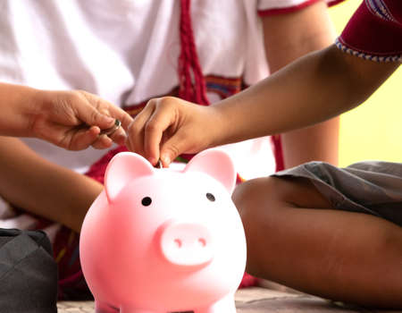 High ground child saving money in piggy bank.の写真素材