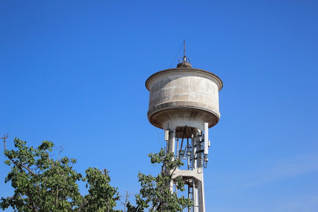 Water tower painted white under blue skyの写真素材