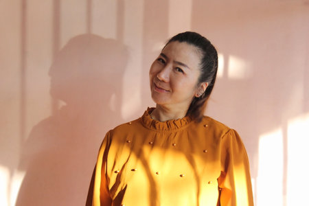 Portrait of a beautiful young asian woman wearing yellow shirt.の写真素材