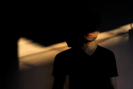 Silhouette of a man in a black t-shirt on a dark backgroundの写真素材