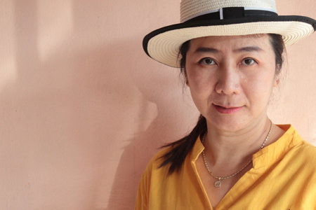 Portrait of thai adult beautiful girl yellow shirt relax and smileの写真素材