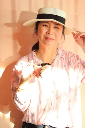 Woman wearing a hat holding coffee cup and smiling.の写真素材