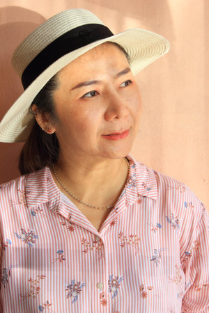 Portrait of Asian senior woman in pink shirt and straw hat.の写真素材