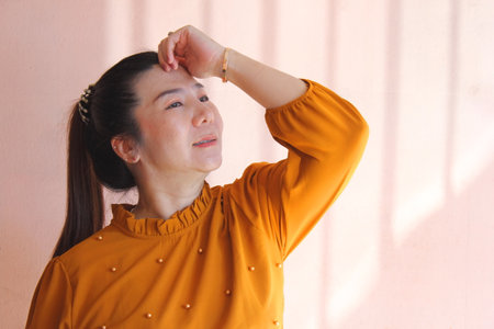 Portrait of thai adult beautiful girl yellow shirt relax and smileの写真素材