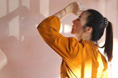 Portrait of female long hair rest hand and touch her forehead., person listening to music.の写真素材
