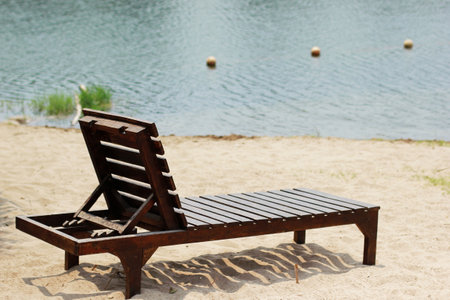 Wooden sun loungers on beach at resort.の写真素材