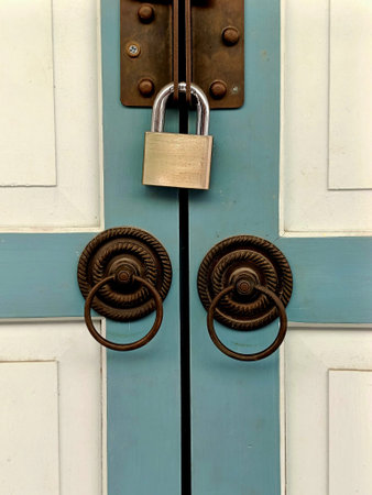 Vintage brass padlock locking a blue wooden door, concept of home security, privacy protection, and safety system.
