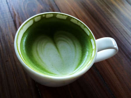 Love Green tea art in white cup on vintage Wooden Table,の写真素材