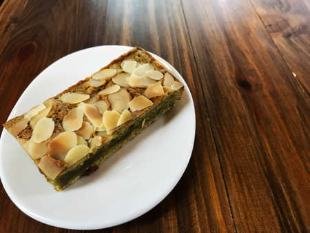 Green tea brownie have almond slice on top in mini white dish on the vintage wooden table, top viewの写真素材