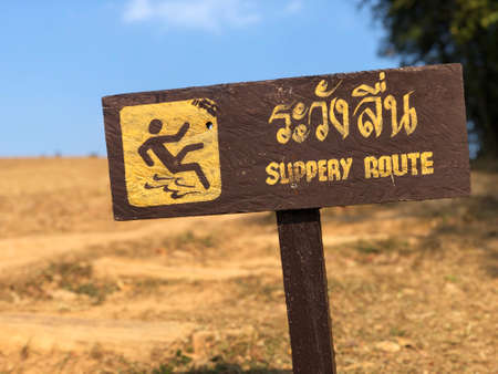 Warning sign for the  "slippery route"  in the mountain Yellow text and sign   on Brown label.の写真素材