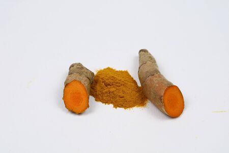 Turmeric powder and fresh turmeric roots isolated on a white background are ingredients in turmeric foods and ingredients in skin care products. Turmeric helps the skin to be strong.の写真素材