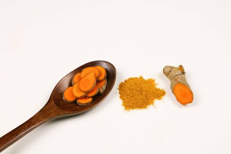 Turmeric powder and fresh turmeric roots isolated on a white background are ingredients in turmeric foods and ingredients in skin care products. Turmeric helps the skin to be strong.の写真素材