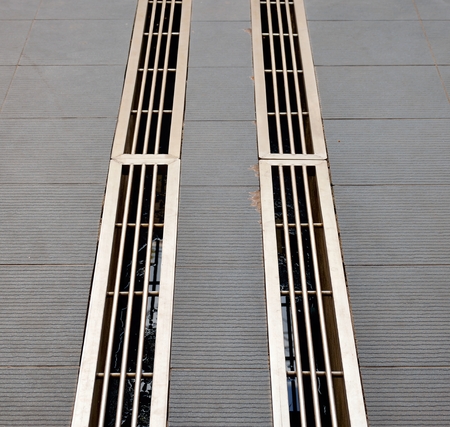 Capturing the pair of dirty ditches which they are covered by stainless gridsの写真素材