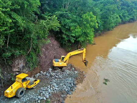 Yellow excavator working on a construction site in the rainforest