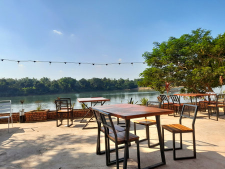 View outside of cafe riverfront with empty tables and chairsの写真素材