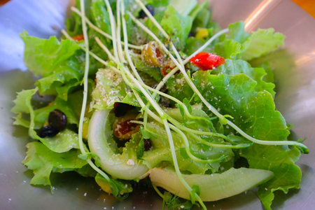 Close up of fresh green salad with olive oil on white isolated background.の写真素材