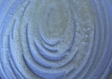Close up textured of a spiral white cream on a blue pan background.の写真素材