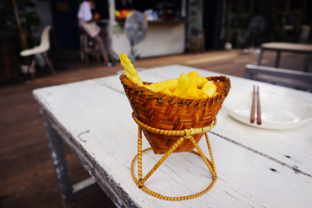 French fries in a basket on a table in a street cafe.の写真素材